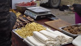 French fries, grilled vegetables, suluguni in pita bread and barbecue on the table of a mobile cafe at the fair. Slow motion video