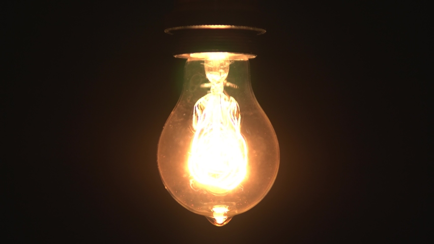 Tungsten light bulb lamp cozy turn on slowly and off over black background, close up shot of old retro vintage light bulb brighten light. Comfort cozy concept. 4k. | Shutterstock HD Video #1045993873