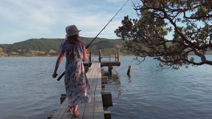 Girl walks out onto the pier to fish