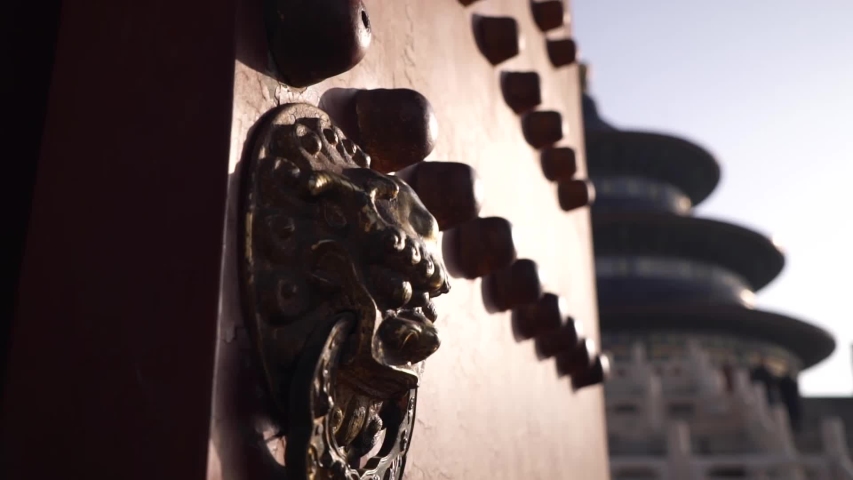 Red Door with amazing handle made of gold plated material at Temple of Heaven in Beijing China sunny day