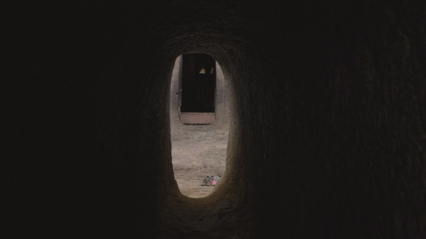 Forward push-in through tunnel to reveal entrance of the Bet Medhane Alem rock-hewn church in Lalibela, Ethiopia