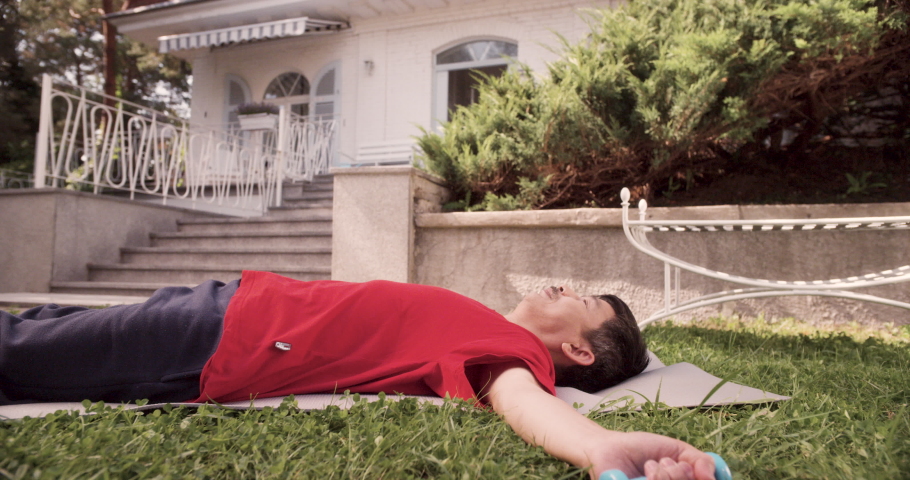 MS Senior Man Exercising with Dumbbells on Garden Lawn. Shot in R3D (6K RED RAW)
