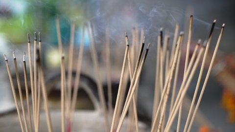 Incense sticks on joss stick pot laced are burning and smoke use for pay respect to the Buddha..