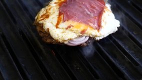 While the egg, pastrami and on the hamburger patties are cooked on the grill, the smoke comes out - Stock Video