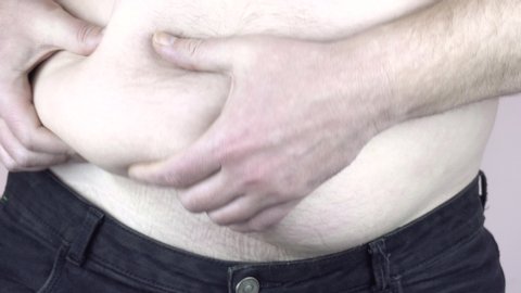 A man shows a big belly. Obesity. Overeating problem. Close-up. 4k