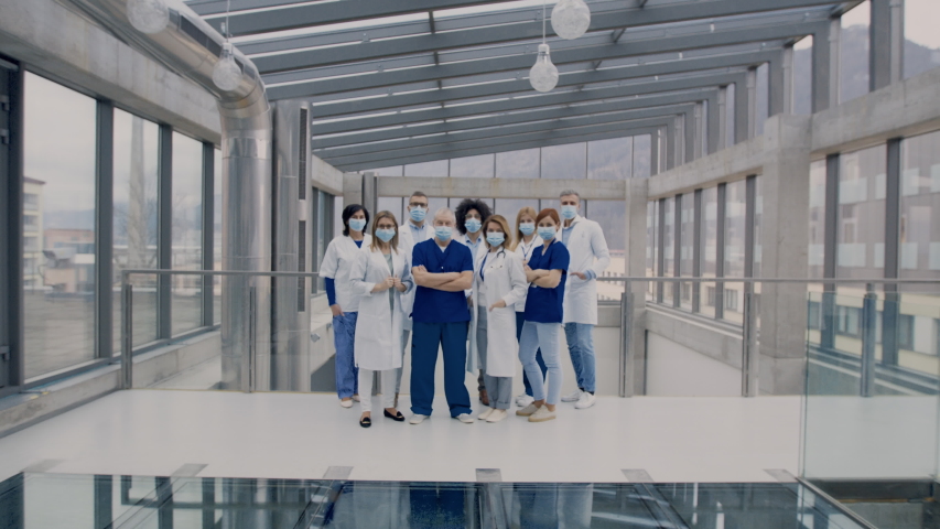 Group of doctors with face masks looking at camera, corona virus concept. Royalty-Free Stock Footage #1046043454