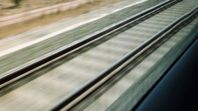View on railroad track from the window of fast train. Bullet train rides on the railway track. 4K - Powered by Shutterstock - Get 15% off with code: PIKWIZARD15