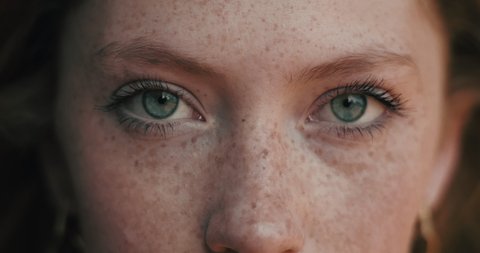 Close up of Woman’s Face, Girl opening her Beautiful blue azzure Eyes, Attractive Ginger. Natural Beauty with Freckles. Gorgeous woman with long Eyelashes and Attractive Appearance. Slow motion.