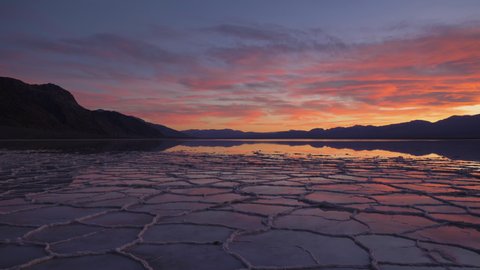 Badwater Basin at Sunset. Salt Crust and Sky Reflection. Death Valley National Park. California, USA. Panning Shot