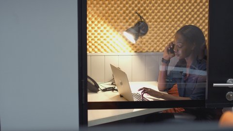 Businesswomen working late in individual office cubicles using laptop and digital tablet - shot in slow motion