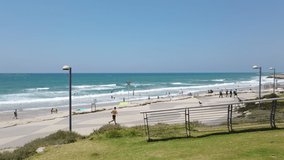 Doing sports at Tel Aviv-Yafo beach boardwalk, man jogging by