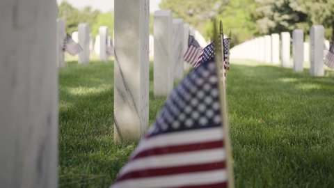 Denver, Colorado, USA-May 26, 2019 - Small American Flags next to white marble gravestones at the  Fort Logan National Cemetery on Memorial Day.