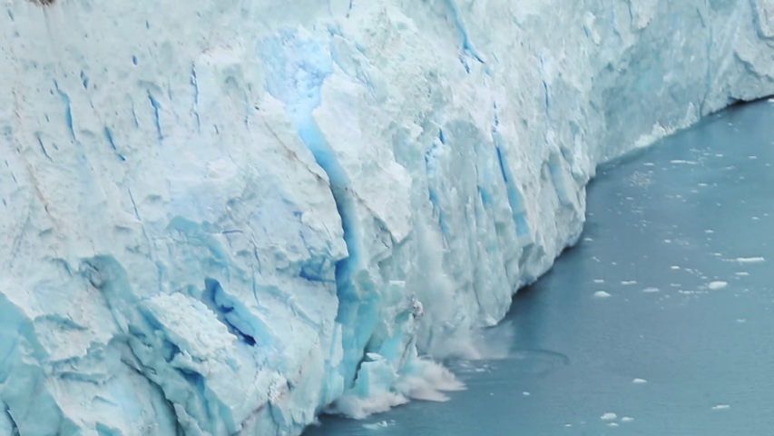 Global Climate changes awareness video - the glaciers are warming and melting faster.  The glacier gives the lake Argentino huge blocks of ice. Ice detaches and falls into the Icebergs Channel. Royalty-Free Stock Footage #1046113537