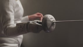 Close-up of a female fencer's epee in a dark and dusty gym in slow motion - Powered by Shutterstock - Get 15% off with code: PIKWIZARD15
