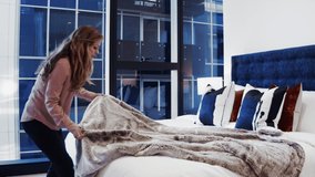 Woman Making Bed in Luxury Appartment