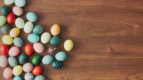 Hands Taking colorful Easter eggs of wooden table. Easter holiday decorations, Easter concept background.
