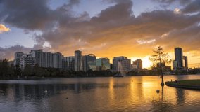 Timelapse of a colorful sunset above Lake Eola and city skyline viewed from the Eola Park in Orlando, Florida. 4K UHD video.