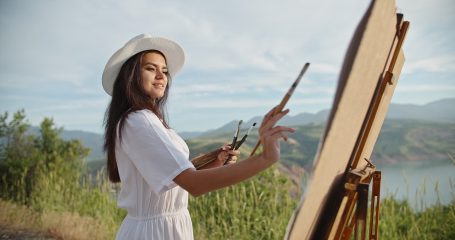 Caucasian female artist enjoying her time in mountains, creating a picture inspired by gorgeous view - hobby, recreational pursuit, inspirational landscape concept 4k footage