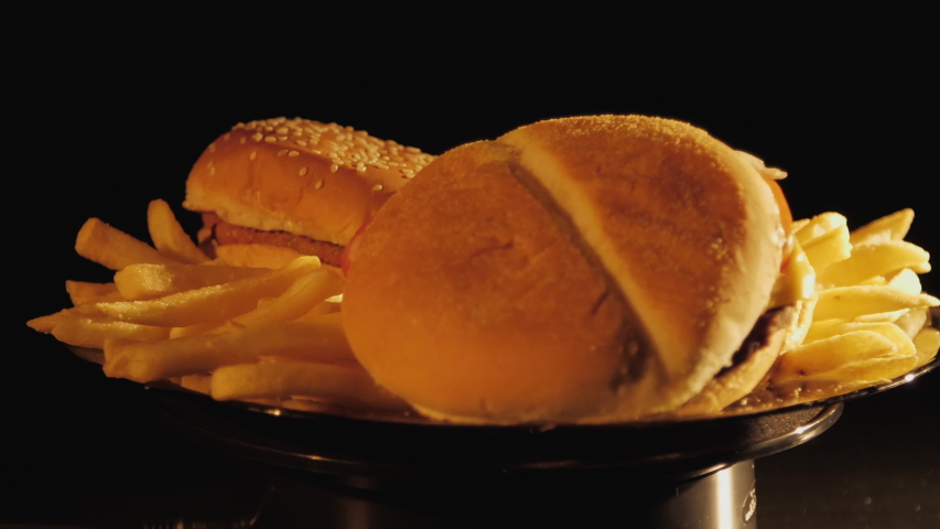 ugly hamburgers, nuggets and french fries cooked in Russia in Siberia spin on a plate and warm up