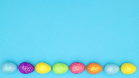 Easter eggs moving in circle on bottom of blue background - Looping stop motion 