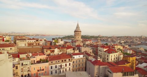 4k footage of Bosporus in the sun set having Galata tower in the middle.  Camera goes up from down.