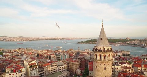 4k footage of Bosporus in the sun set having Galata tower in the middle.  Camera rotates around the Galata tower.