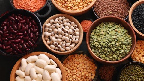 Legumes, a set consisting of different types of beans, lentils and peas on a black background, top view, close up, 4k. The concept of healthy and nutritious food
