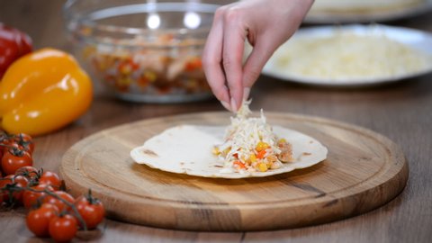 Laying out the filling on the tortilla, making quesadilla, taco, burrito. Mexican cuisine.