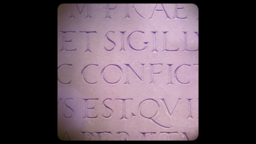 Square image filter over vintage film with slow pan from right to left over old roman text letters words in Latin language carved in red stone