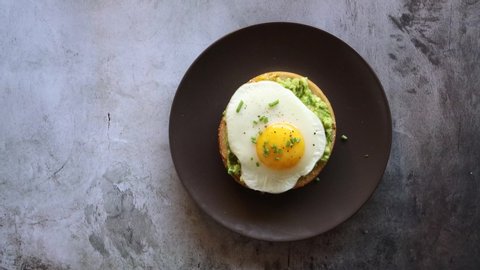 Serving a Bagel with Egg and Avocado on a concrete background with room for copy