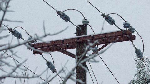 Slow motion snowfall and ice storm on electric utility pole in winter. 