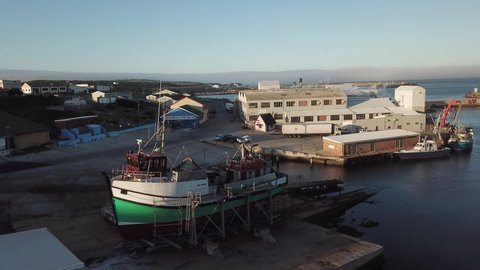 Gans Bay, Garden Route, Western Cape, South Africa, 12.06.19: 4K summer sunny morning aerial drone video, commercial harbour piers, vessels boats, fishing processing factory, Indian Ocean coastal town