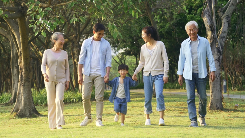 Happy multi generation asian family having a good time walking in park