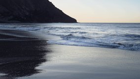 Relaxing video with seascape, long calm waves on sandy beach on sinrise