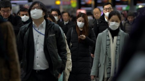 Tokyo, Japan-04 February, 2020: Slow motion of Japanese business men and women wear face masks. People wearing mask at metro as precautionary measures during coronavirus from Wuhan, China