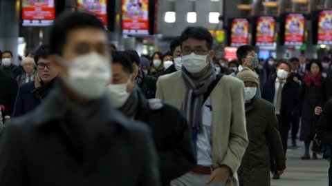 Tokyo, Japan-04 February, 2020: Slow motion concept of coronavirus quarantine, MERS-Cov. Large crowd of business people with medical face mask. Air pollution. Virus has caused emergency situation.