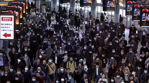 Tokyo, Japan-04 February, 2020: Slow motion concept of coronavirus quarantine, COVID-19. Large crowd of business people with medical face mask. Air pollution. Virus has caused emergency situation.