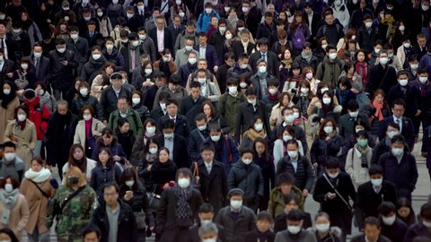 Tokyo, Japan-04 February, 2020: 4K, Concept of coronavirus quarantine, COVID-19. Large crowd of business people with medical face mask. Air pollution. The virus has caused emergency situation.