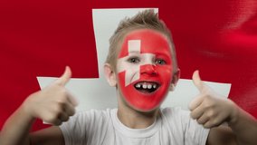 Swiss fan is celebrating. Boy with the country flag is watching the match. Football fan at the stadium is screaming. Soccer. Footballer with a painted face. Winner. - Powered by Shutterstock - Get 15% off with code: PIKWIZARD15