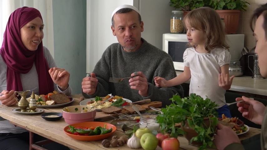 Happy authentic arabic muslim family have a dinner in kitchen together. Concept of religion, lifestyle, social, family. Slow Motion