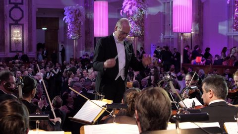 VIENNA AUSTRIA JAN 18 2018 classical orchestra performing live Austrian waltz music on a Viennese ballroom prom dance at the Hofburg Palace, conductor in front of orchestra, background ballroom