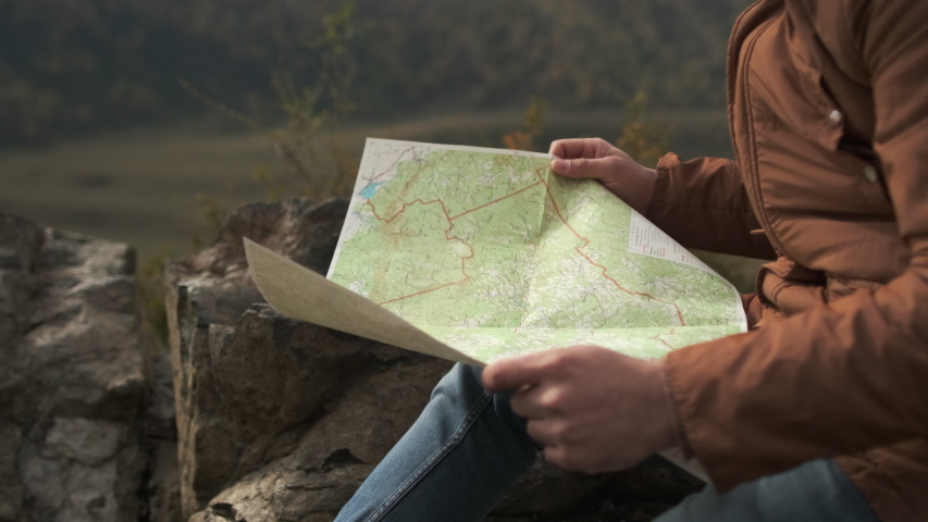 Close up of hands of hiker tourist traveler man looking for map route, traveling on mountain. Active lifestyle hiking enjoying vacation travel tourism backpacking adventure landscape nature 4 K slowmo Royalty-Free Stock Footage #1046191474