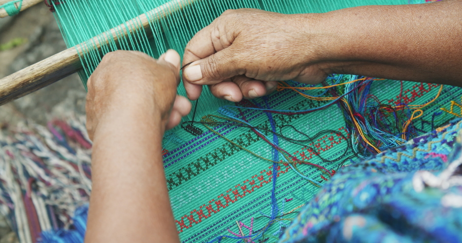 Close up of hands weaving vibrant colorful Guatemalan textiles in the streets of Antigua | Shutterstock HD Video #1046203309