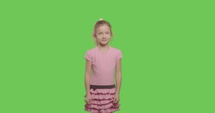 Shocked child open mouth. Surprised girl cover face with hands over green screen. Close up of scared female model expression on chroma key . 4k raw video footage slow motion 60 fps