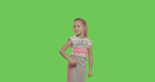 Happy young girl dancing and smiling over green screen background. Happy smiling child on Green Screen, Chroma Key. 4k video footage slow motion 60 fps
