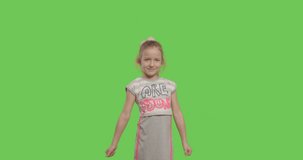 Young cheerful caucasian child in sunglasses showing like sign over green screen background . Girl making thumbs up on chroma Key. 4k video footage slow motion 60 fps