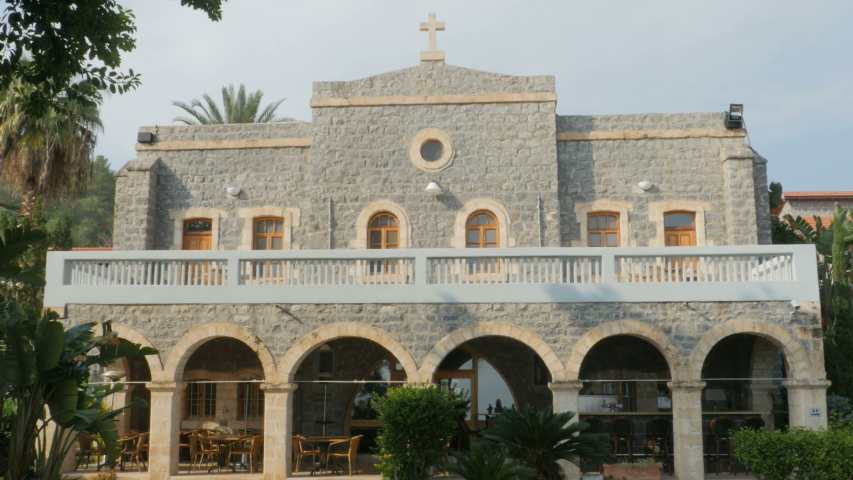 Front view of a mansion with Christian cross or a religious building with facade made of blue stone located in Israel