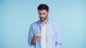 man pointing with finger at smartphone with green screen isolated on blue