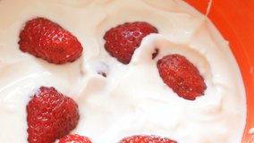 milk yogurt or cream and fresh berries in bowl rotate, healthy food and drink concept, closeup