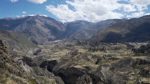 Panoramic view of the scenic landscape in the Colca Canyon (Cañón del Colca) in the Andes Mountains of Peru with stepped agricultural Inca terraces from a viewpoint. Time-lapse video. 